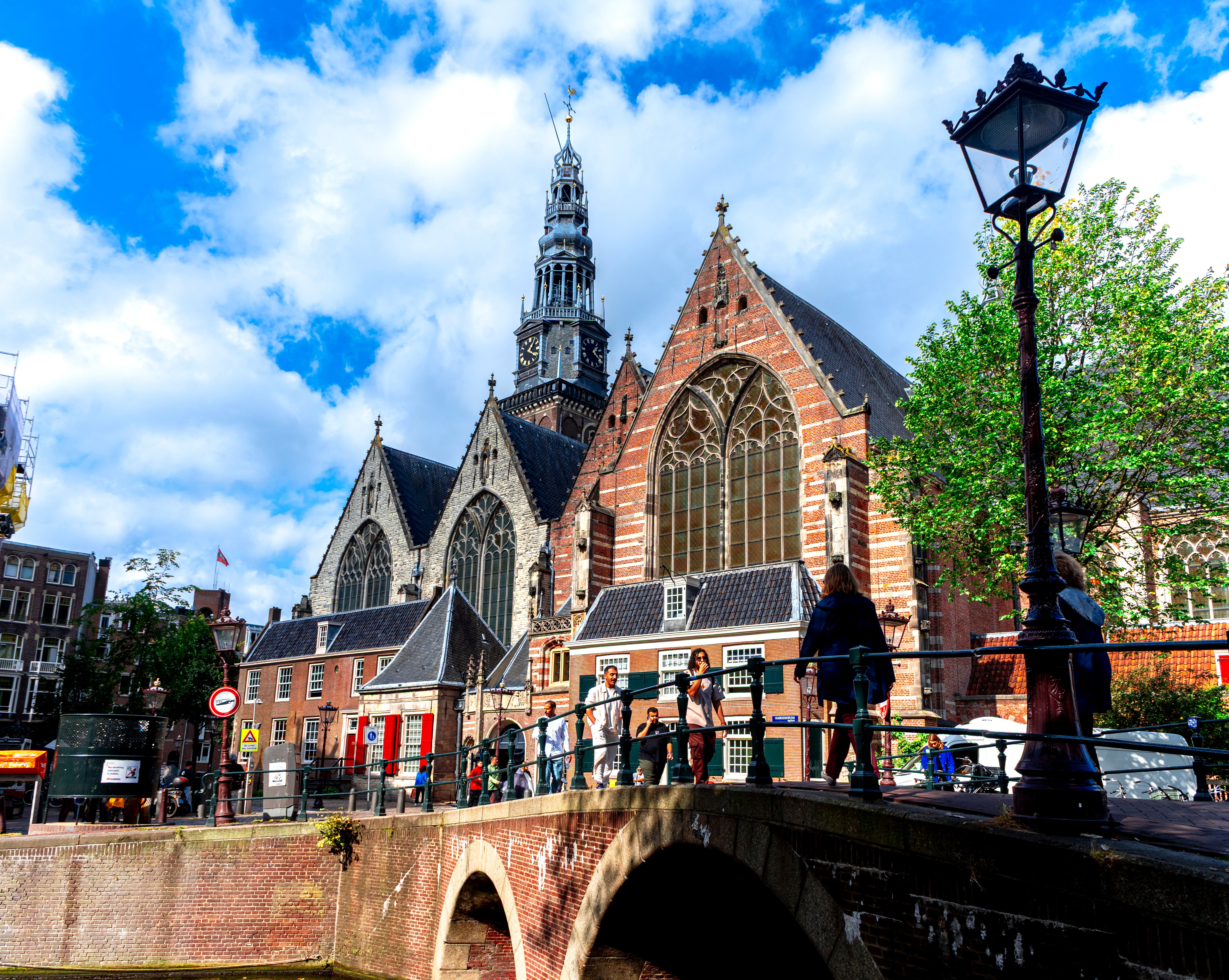 Vista de la iglesia Oude Kerk en Amsterdam con gente en el puente