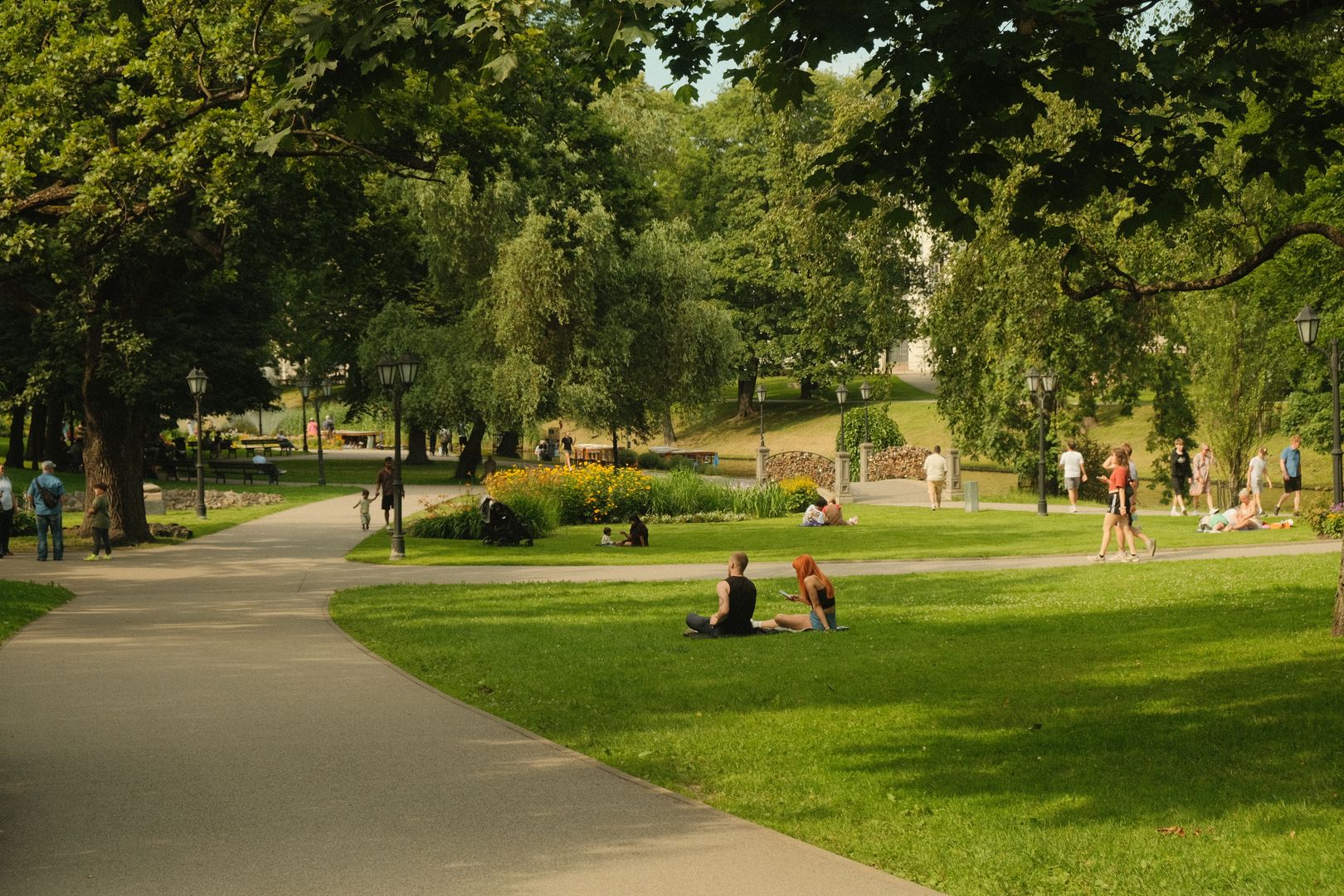 Gente paseando y descansando en el césped de un parque urbano