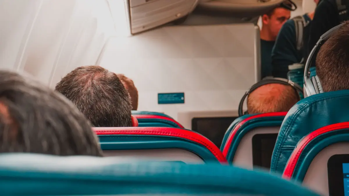 Persona usando el móvil en el asiento de un avión durante el vuelo