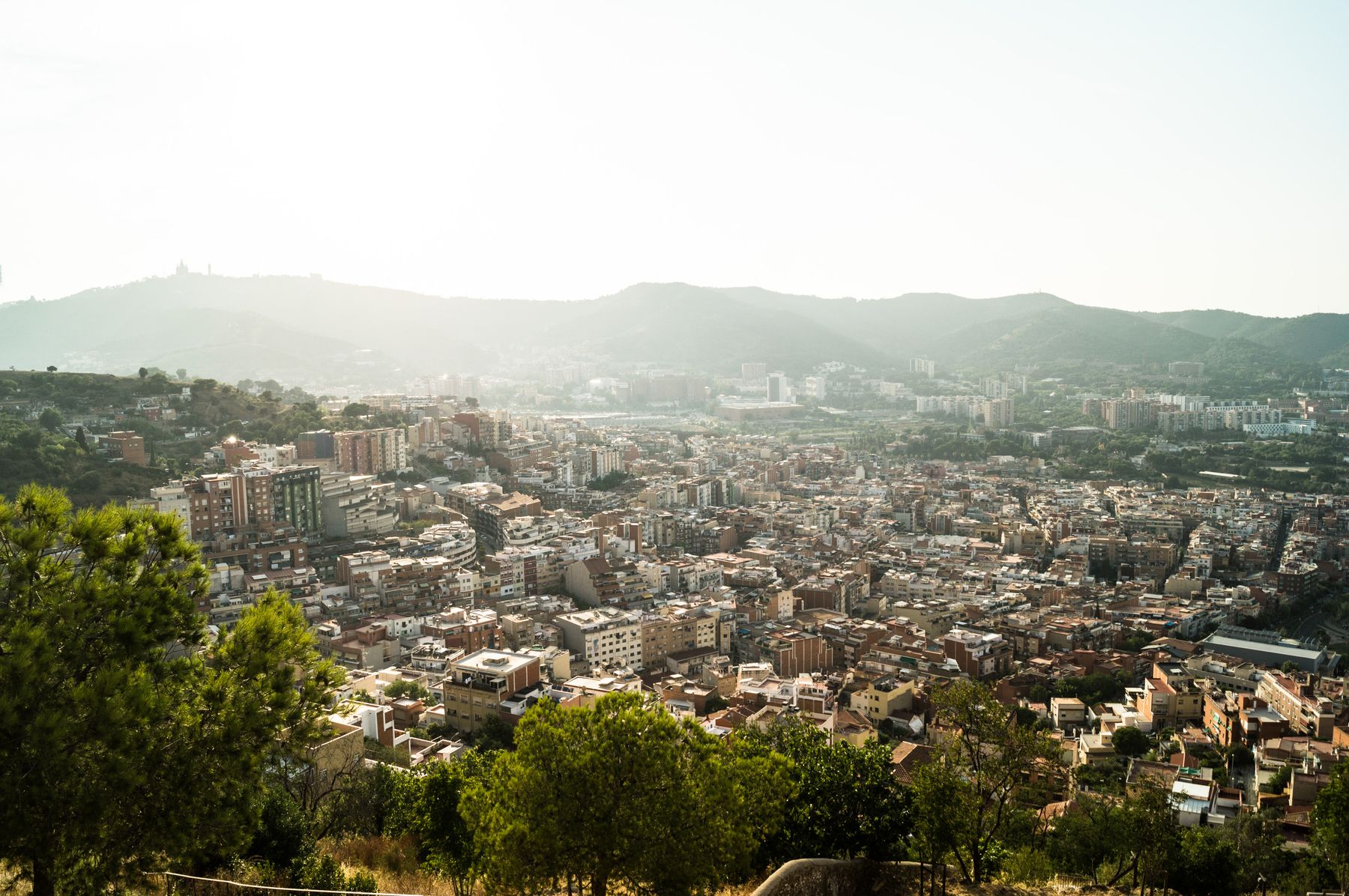 Vista aérea de Barcelona rodeada de montes, con la colina de Montjuïc en primer plano