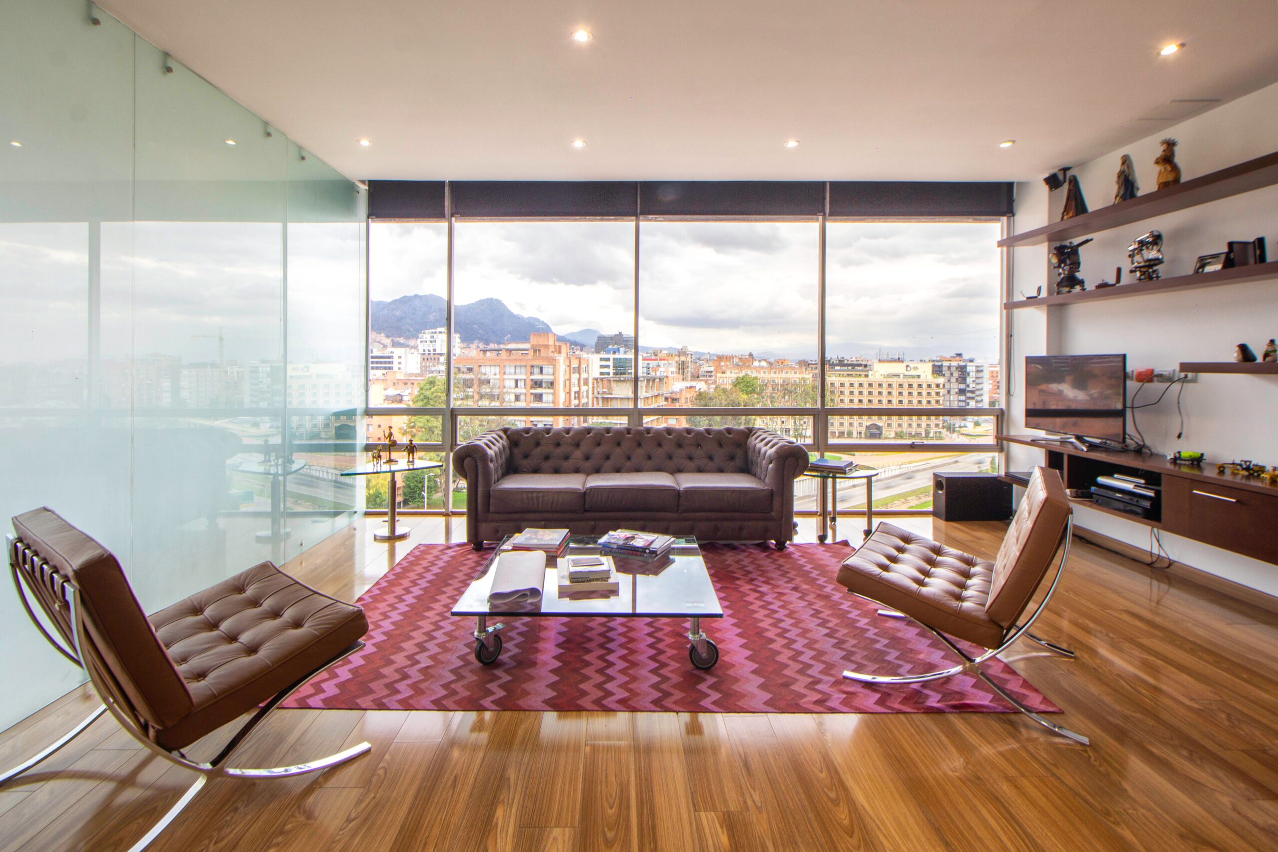 Salón minimalista de lujo con grandes ventanales y vistas a la ciudad