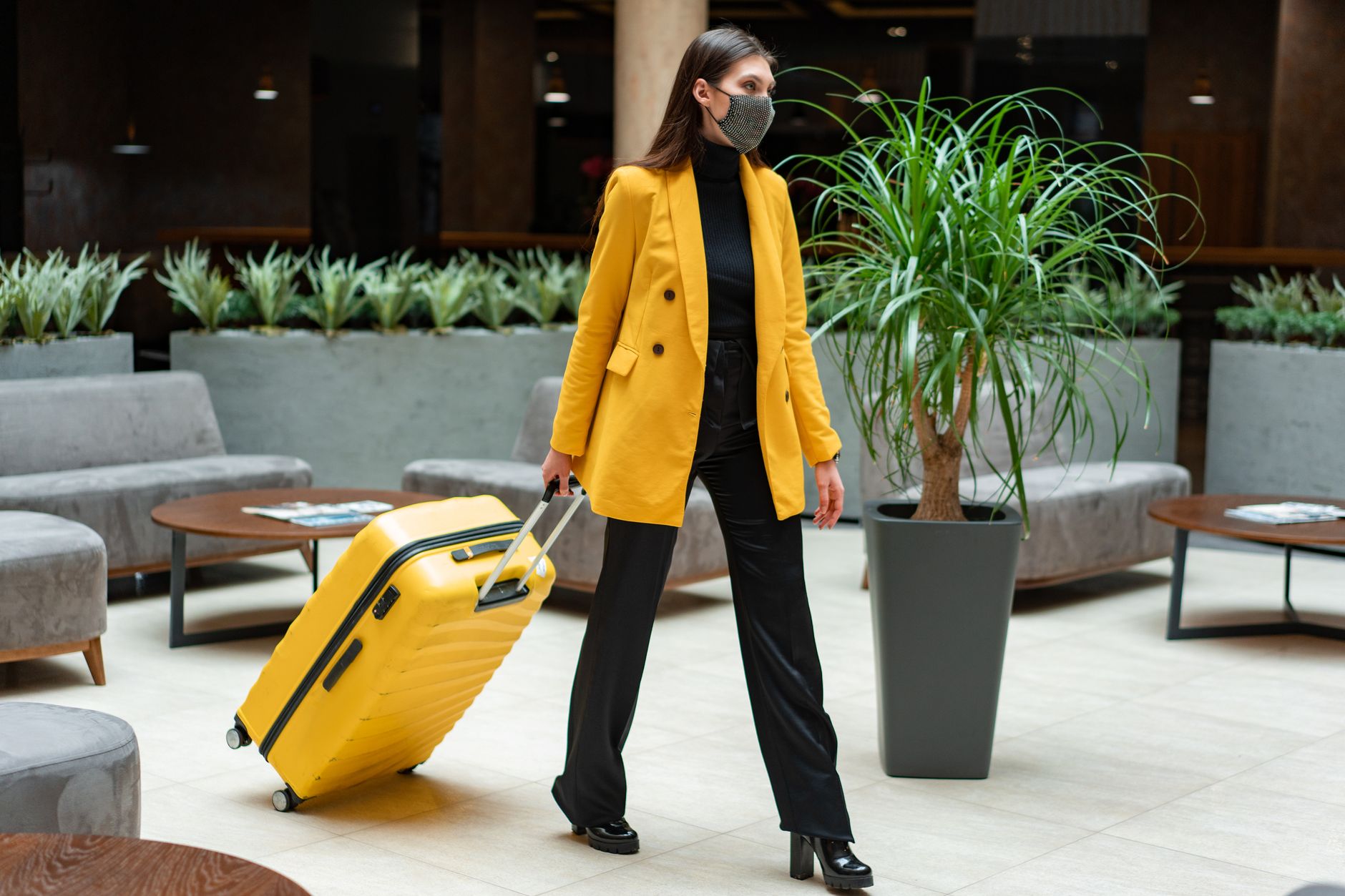 Mujer viajando sola con maleta en el lobby de un hotel