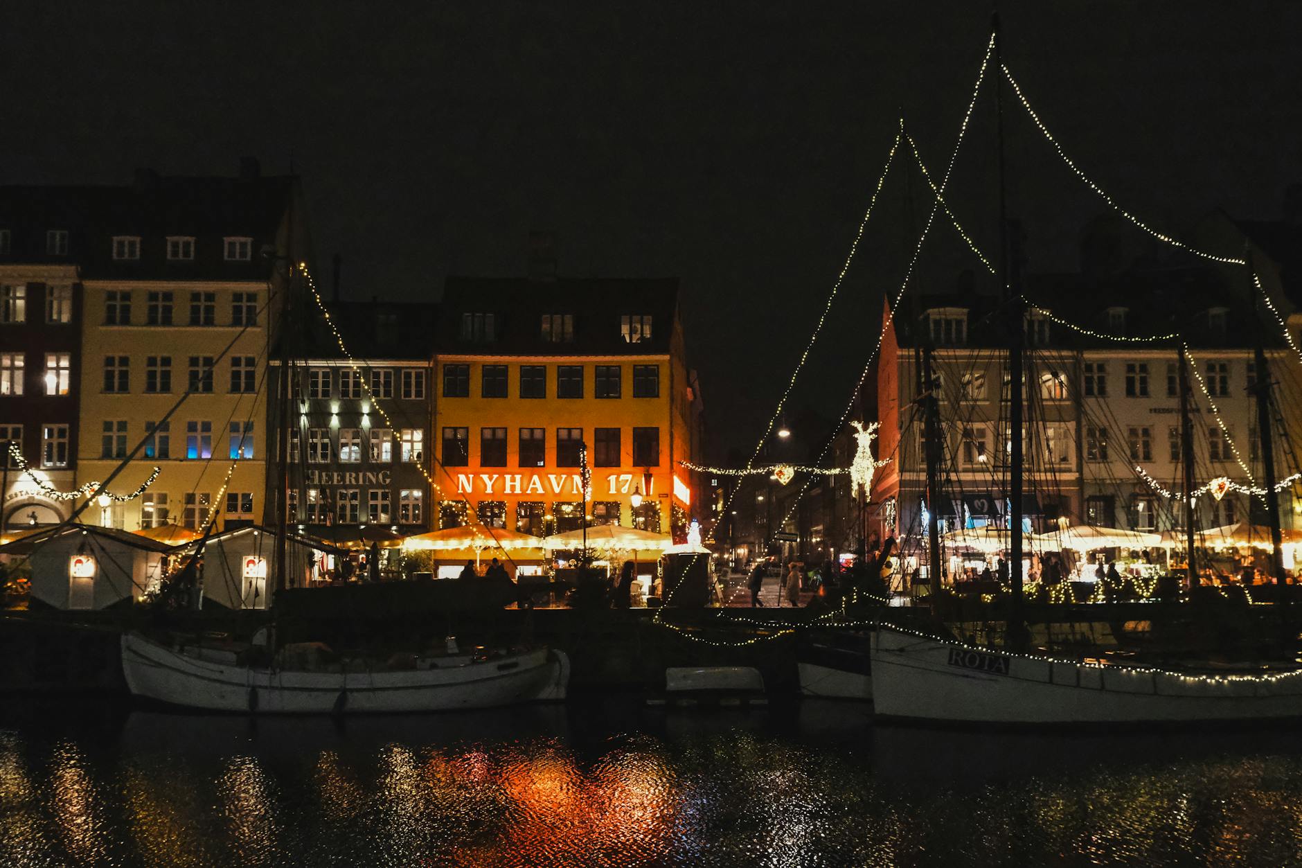 Copenhague en 2026: guía con criterio de la capital más ciclista, gastronómica y «hygge» de Europa 4 Nyhavn de noche con luces festivas reflejadas en el agua