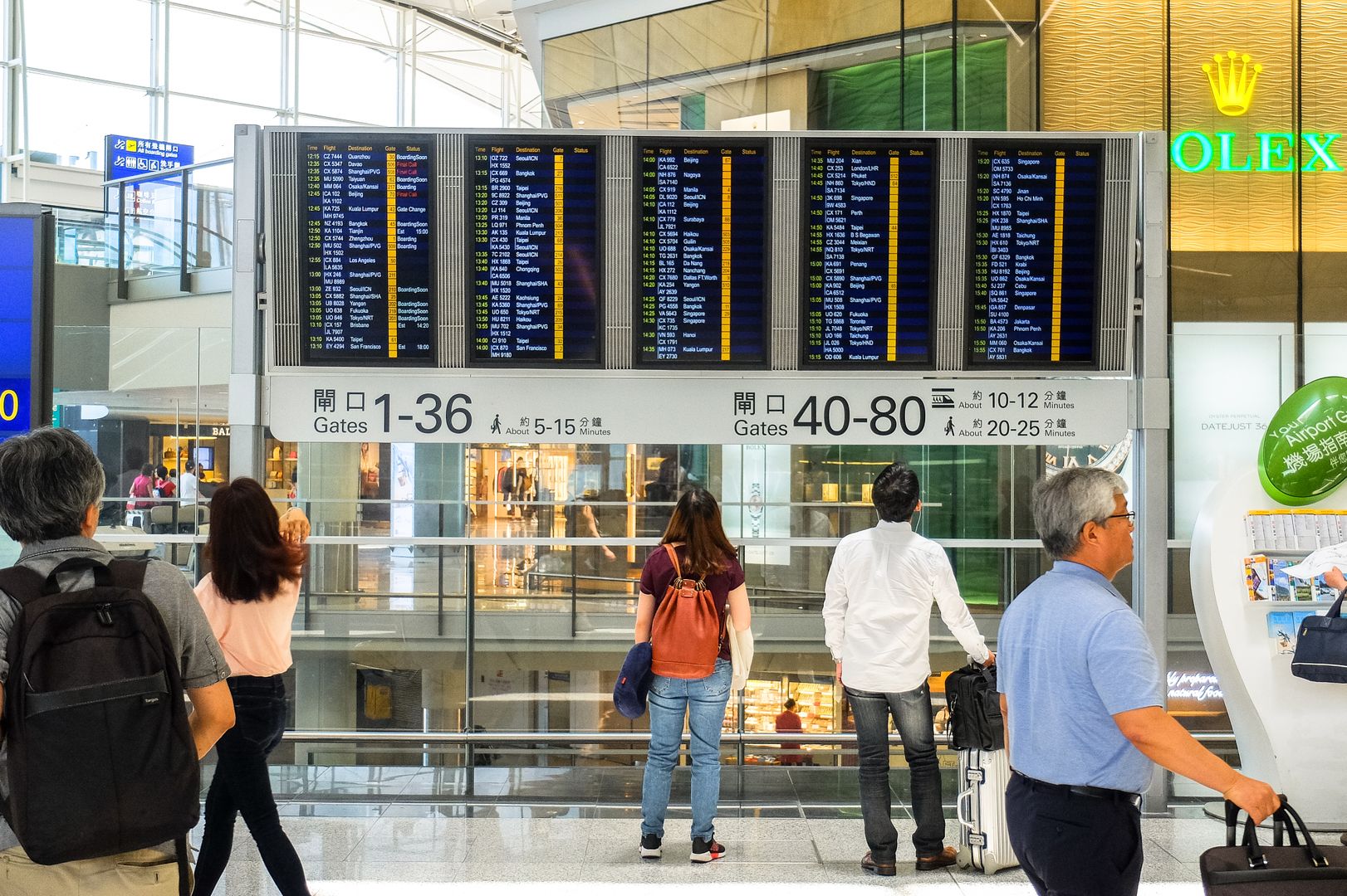Pasajeros consultando el panel de salidas en un aeropuerto